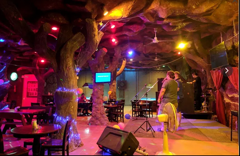 The interiors of Funky Monkey Bar with couples on the stage singing in Koh Lanta