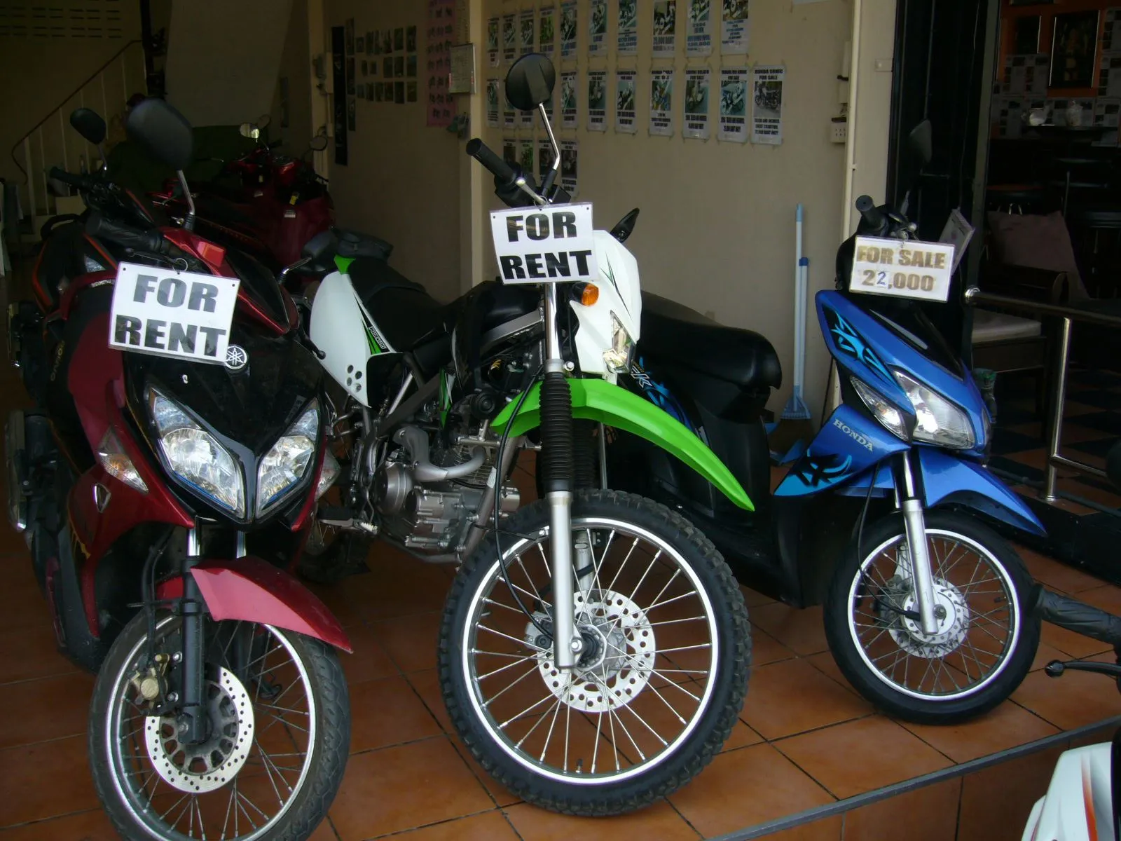 Three motorcycles are displayed for rent at Hua Hin Motorcycles in Hua Hin