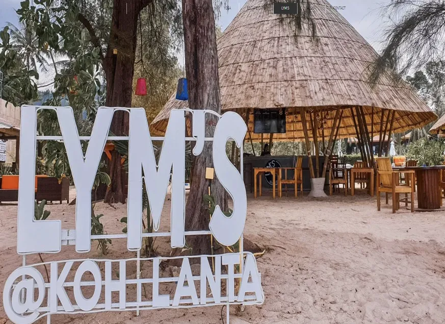 The white signage of Lym’s in front of the tepee hut structure of the bar in Koh Lanta