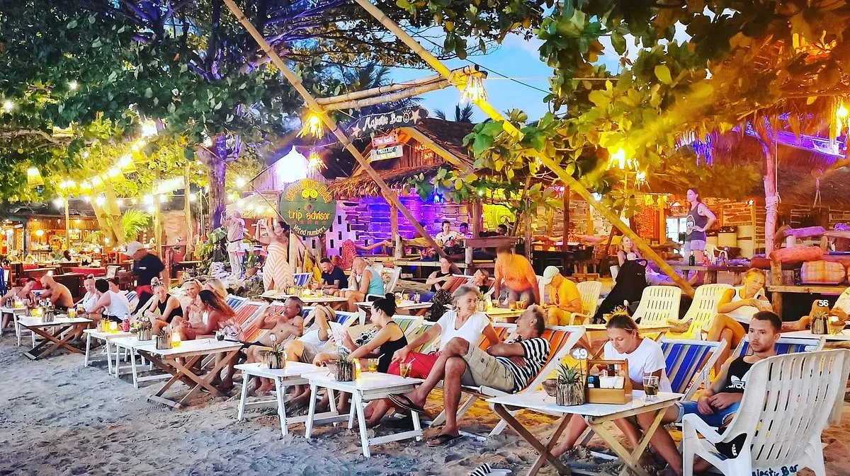 People chilling on the sun lounger chairs while drinking cocktails outside the Majestic Bar in Koh Lanta