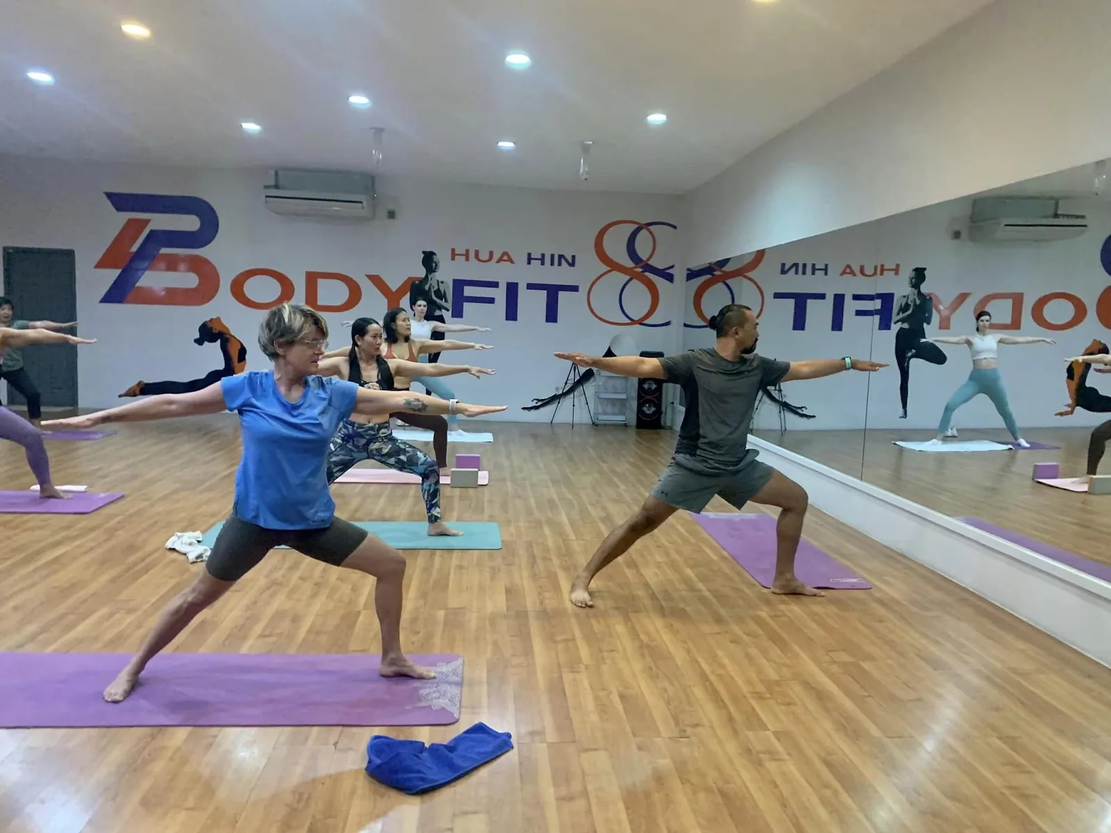 A group of women led by a male instructor in a yoga class at Body Fit 88 in Hua Hin