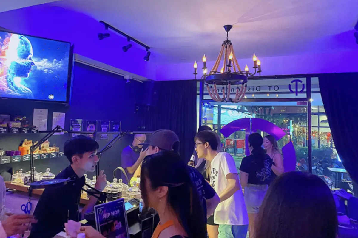 Inside the purple-lighted shop of the The OT Dispensary, full of customers and with a DJ playing music in the background