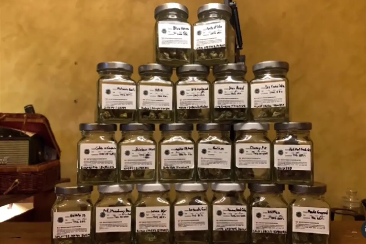 A stack of clear glass jars containing various cannabis strains offered by Wake N’ Bake Weed Dispensary in Chiang Mai