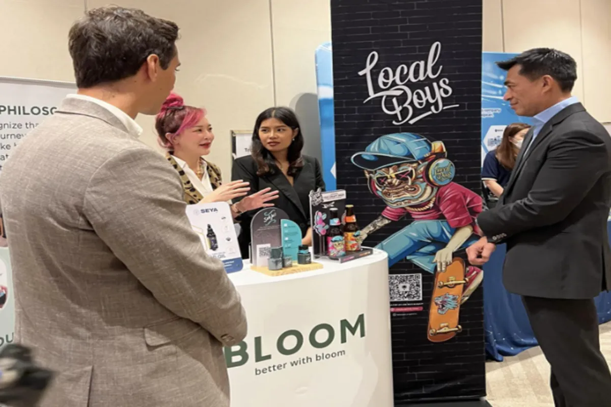 A group of four people discussing the various cannabis product offerings of Bloom during an expo in Bangkok