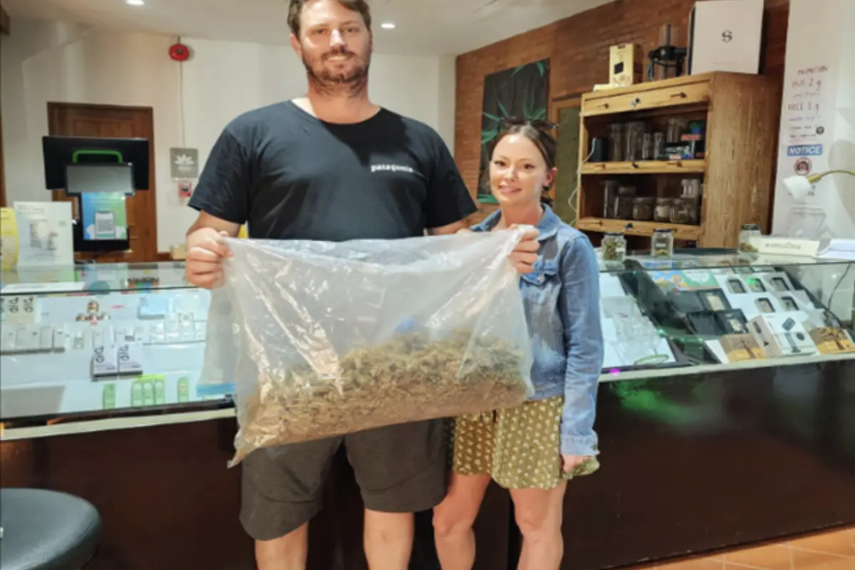 A couple showing a big bag of weed bought from Weed Connection cannabis dispensary in Chiang Mai