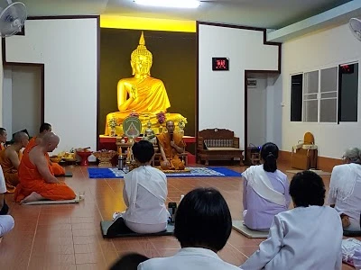 A group of people sitting on the floor and meditating together with the monks at the Buddhist Community Development Center 