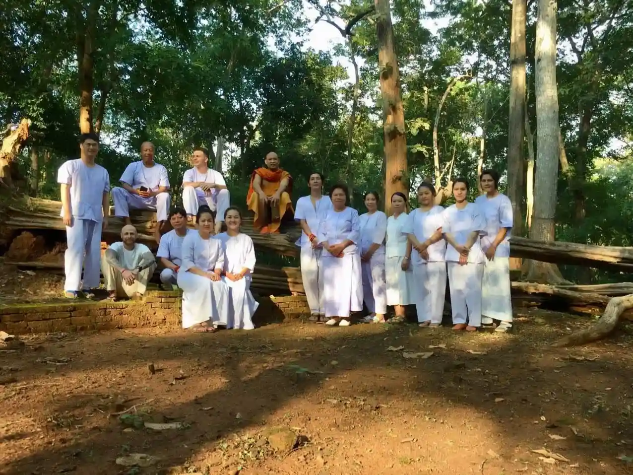 A group of people wearing white clothes and gathering for a photo at Meditation Center Wat Umong
