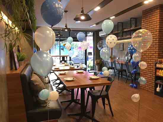 The interior of Cafe Yu is decorated with several blue-themed balloons in Surat Thani
