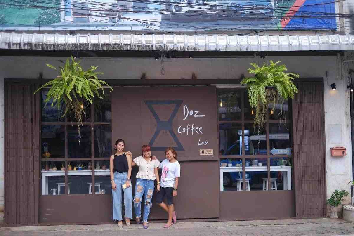 Three women posing outside DOz Coffee Lab in Surat Thani