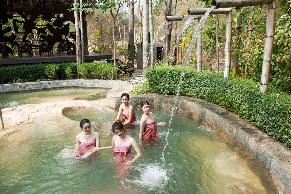 Four women bathing in the hot spring pool at Hot Valley Hot Spring and Fish Spa in Kanchanaburi