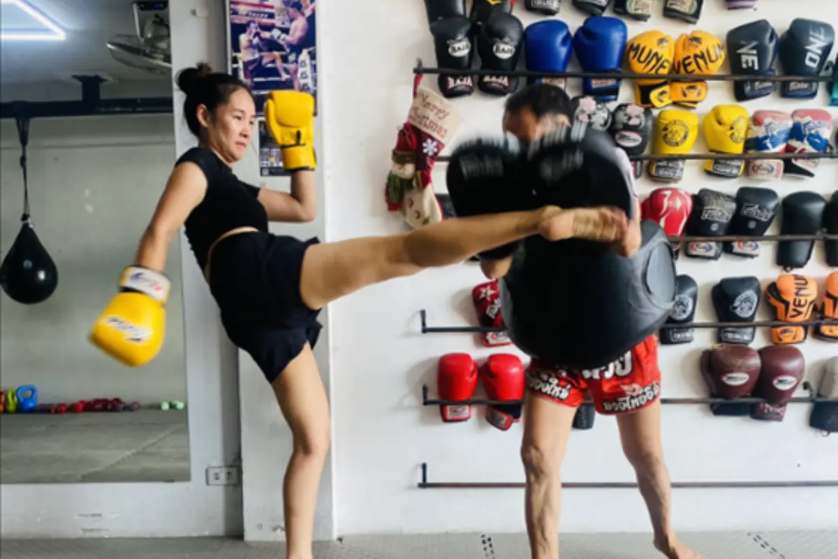 A woman is practicing her kicks with his instructor at BBN Boxing Gym in Chiang Mai
