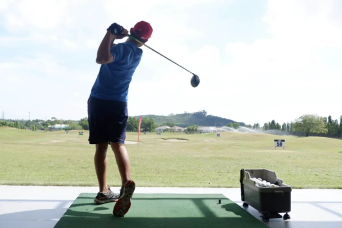 A man is playing golf at the driving range of Phunaka Golf Course in Phuket.