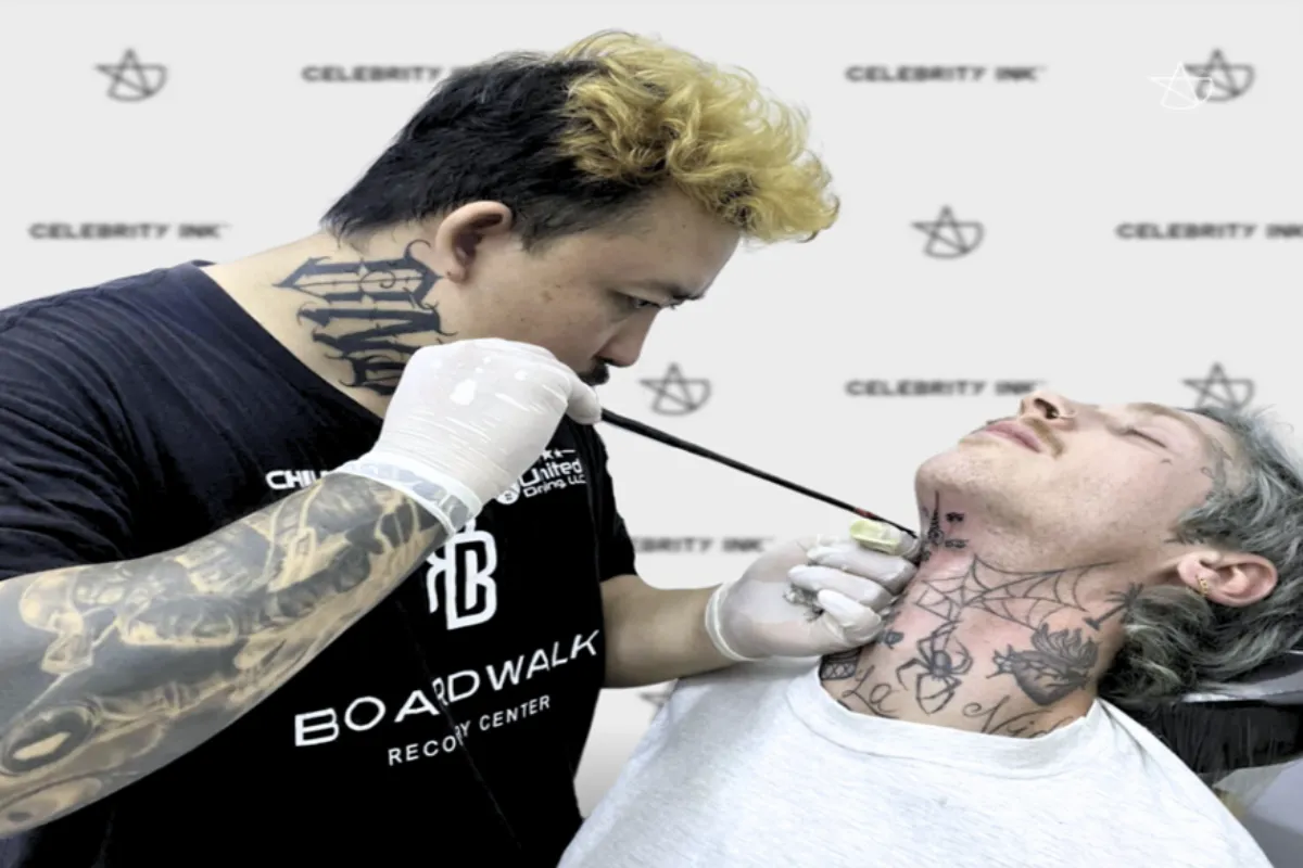 An artist is doing a hand poked tattoo on a man’s neck at the Celebrity Ink Tattoo Studio in Chiang Mai