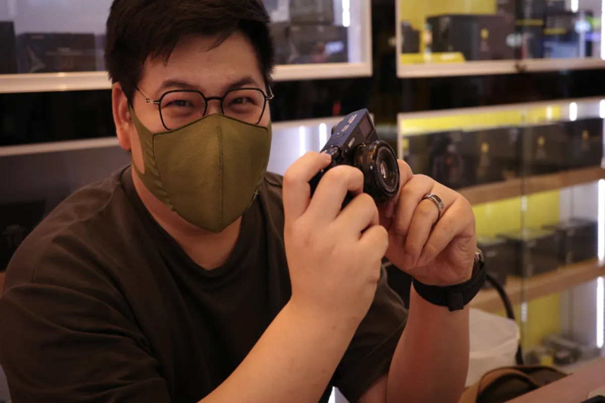 A man is holding a camera inside the Zoom Camera Store in Chiang Mai