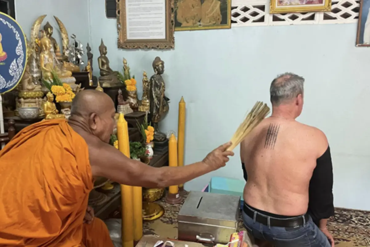 A man is getting his Sak Yant tattoo blessed by the monk at Home Art Tattoo Lamai Beach in Koh Samui