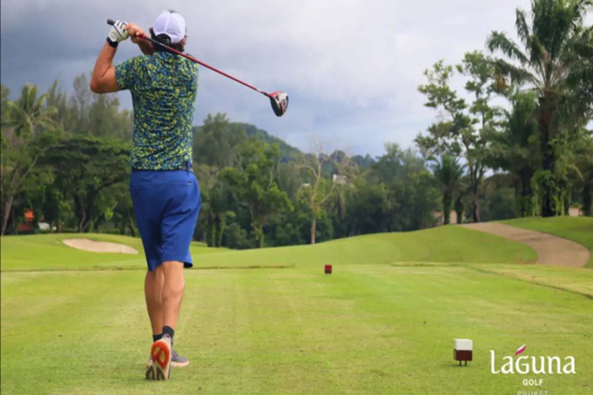 A man swinging his club while playing golf at Laguna Golf in Phuket.