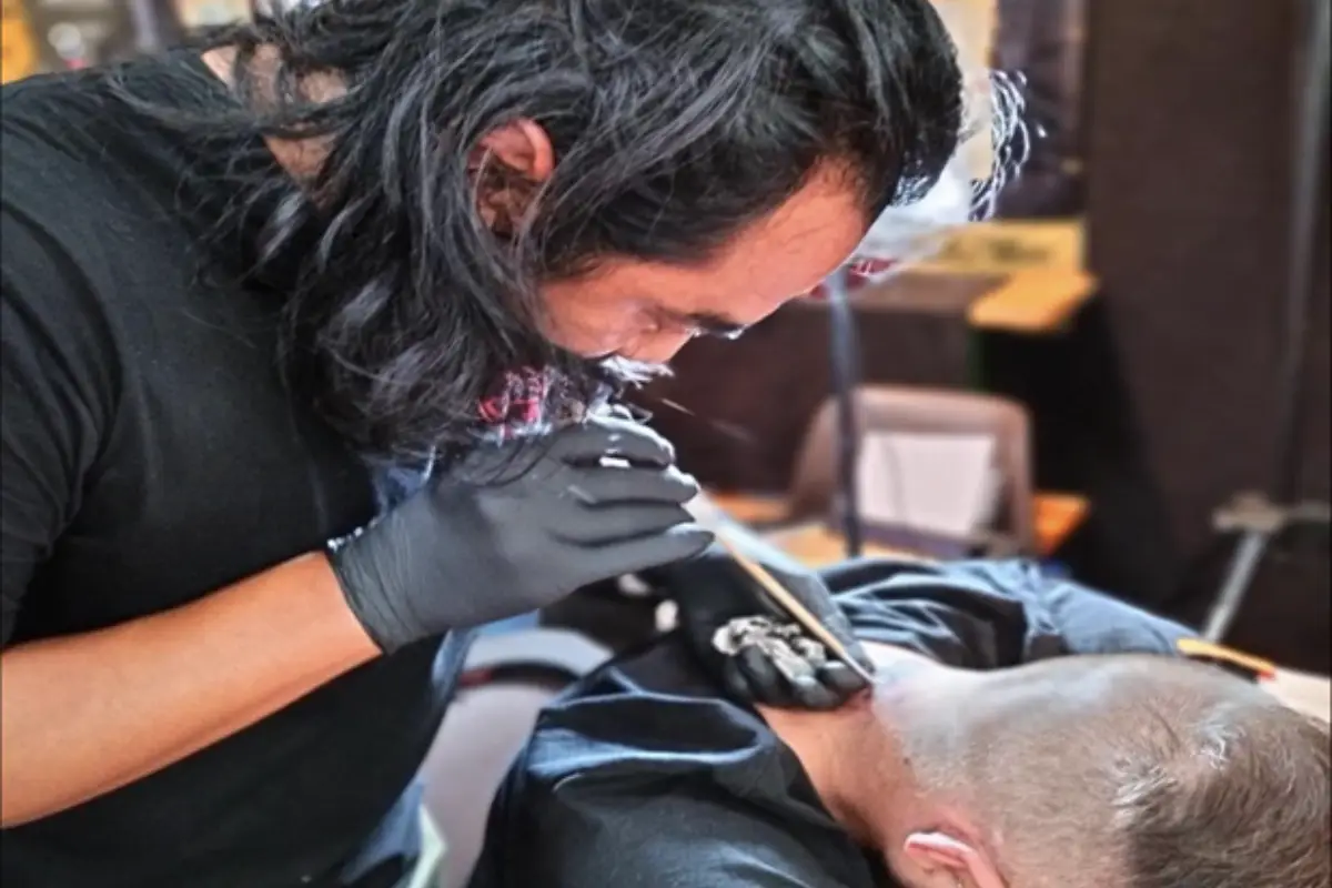 A man getting a Sak Yant tattoo on his nape at Metal Tattoo in Koh Samui