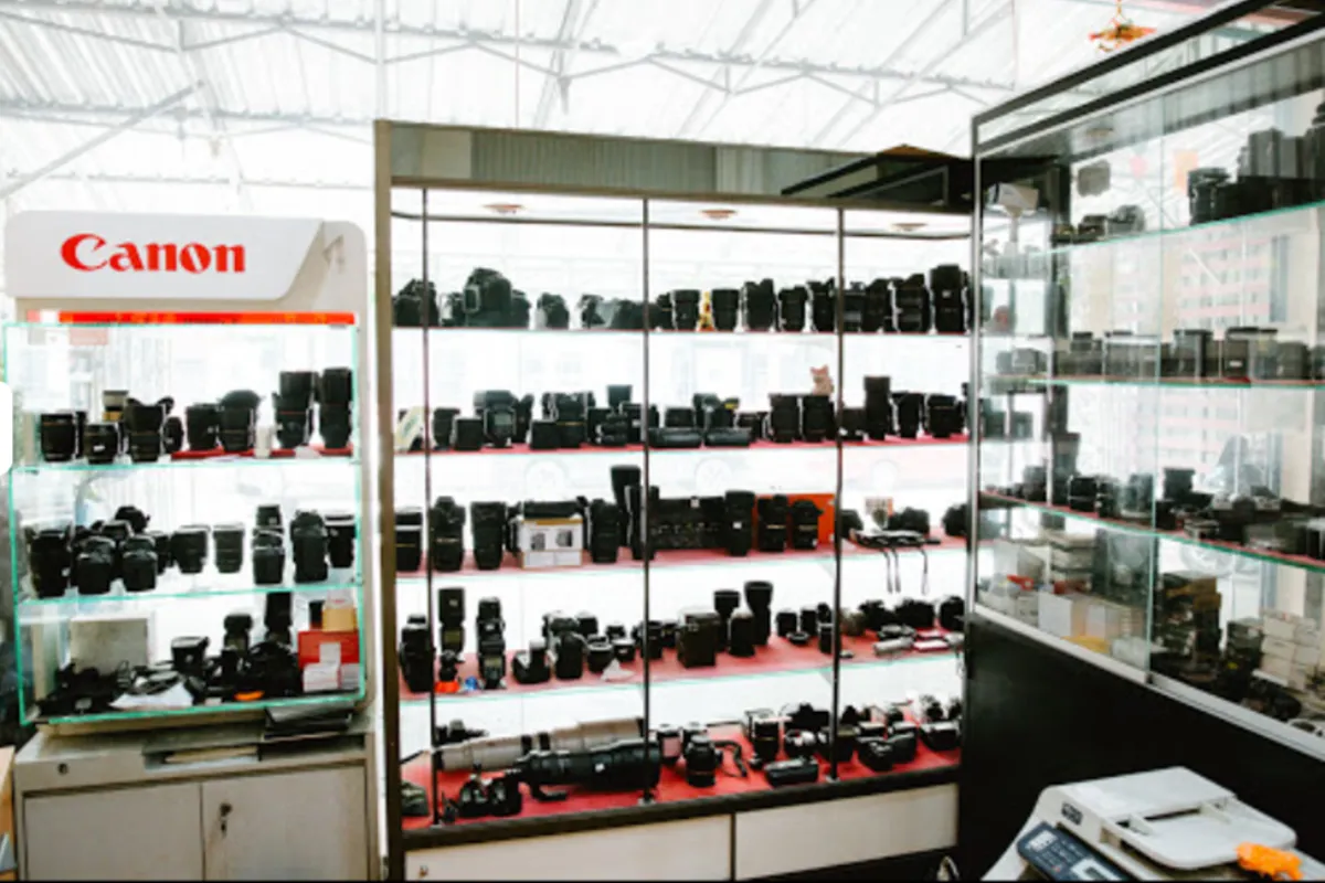 A view of the wide selection of cameras, lenses, and other products displayed on the glass shelves at the Panorama CM store in Chiang Mai