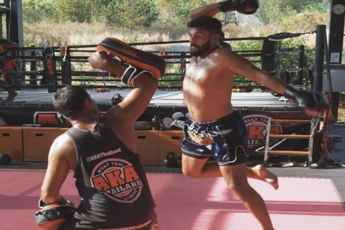 A trainee is doing a jumping move towards his trainer at AKA Muay Thai Boxing Gym in Phuket