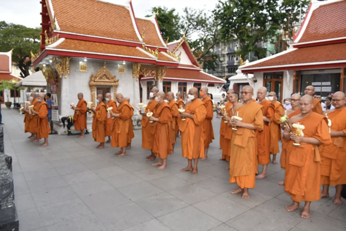 A group of monks gathered outside Wat Chana Songkhram during a candle procession activity