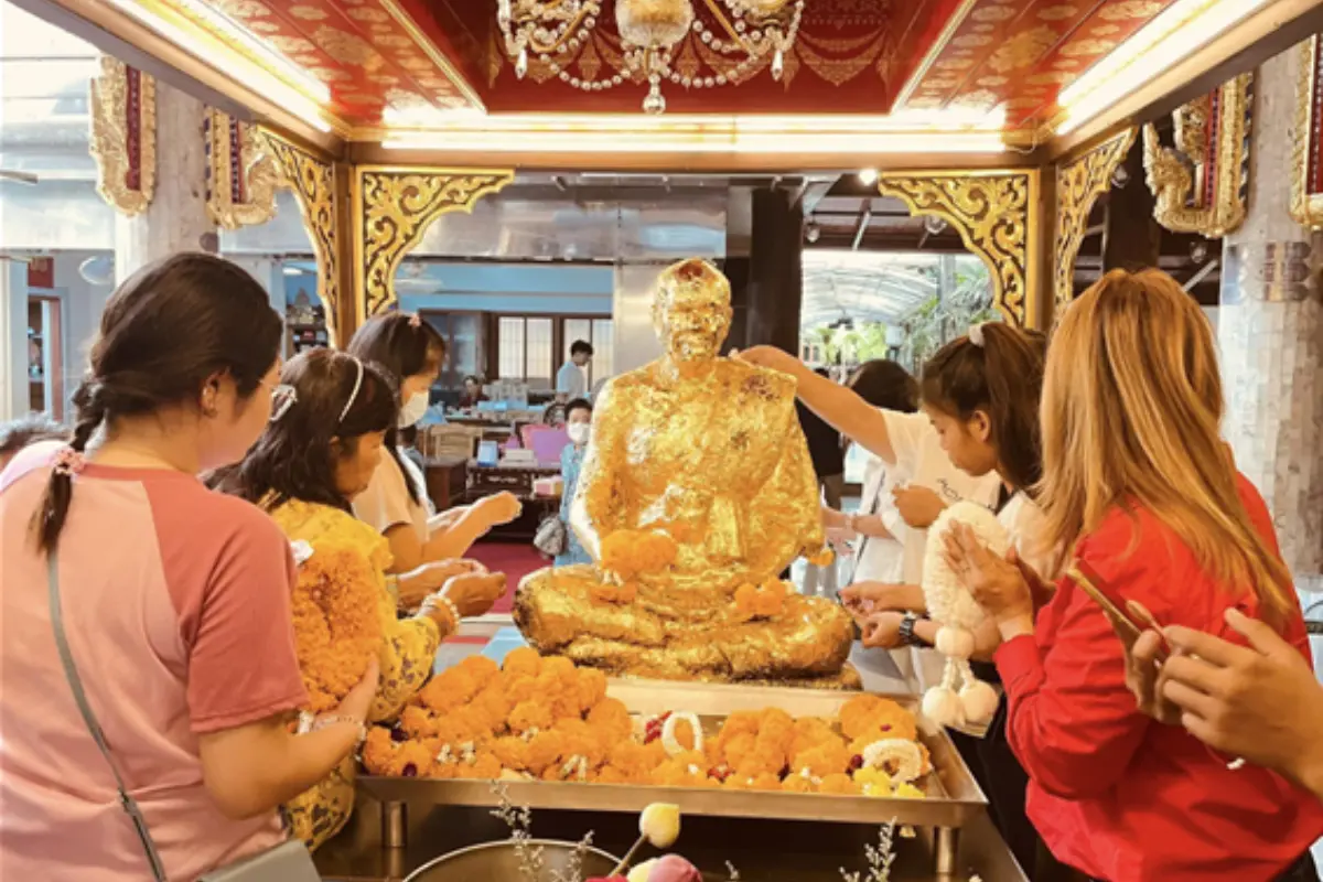 People giving out their offerings in one of Wat Paknam Bhasicharoen’s golden statue