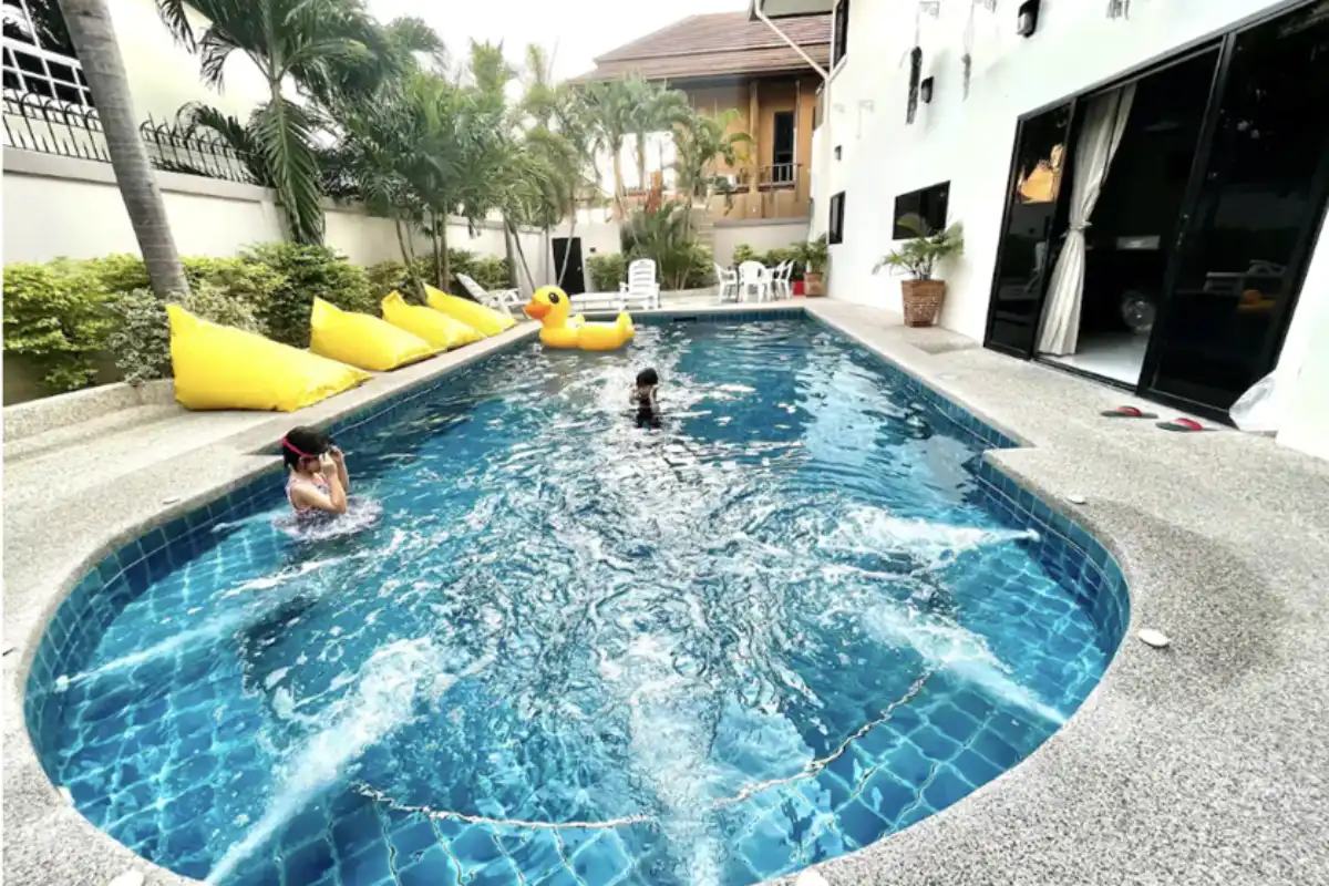 Two children swimming in the pool at the Luxury Pool Villa in Pattaya