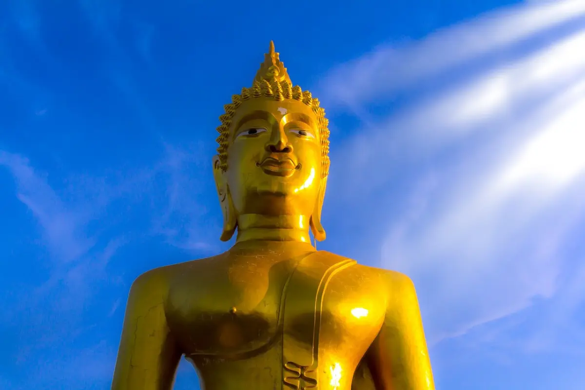 A close-up of the Big Golden Buddha across the clear blue sky