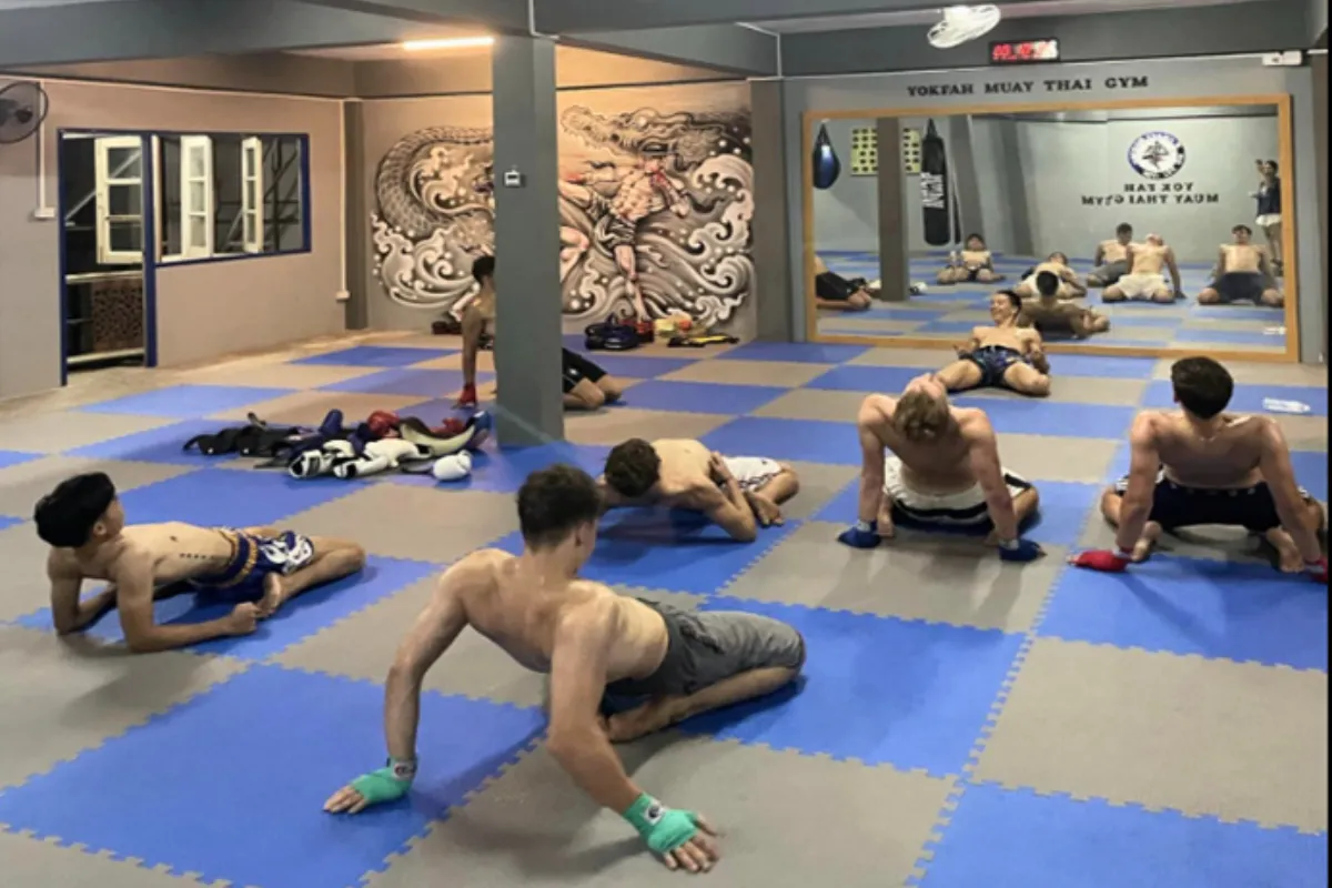 A group of trainees doing warm-up exercises at Yokfah Muay Thai Gym in Chiang Rai