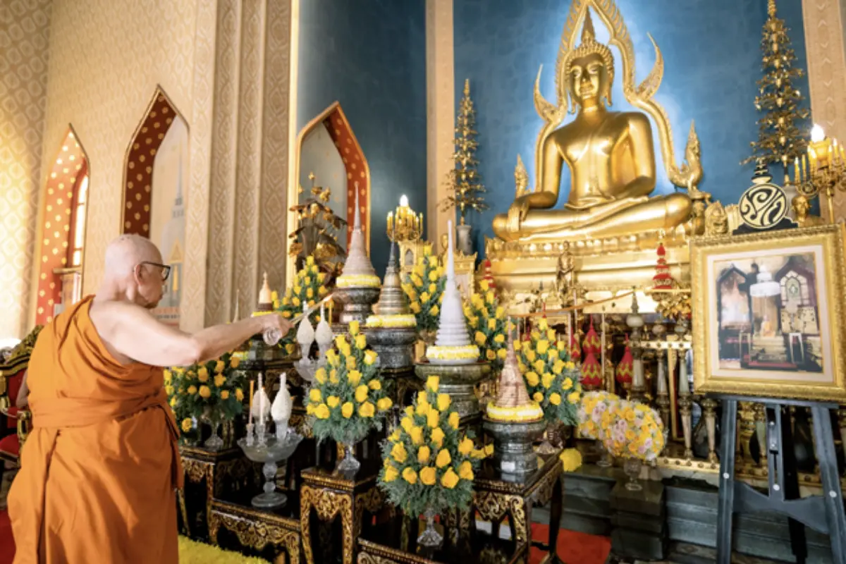 A monk is lighting the candles at the altar in Wat Benchamabophit Dusitwanaram in Bangkok