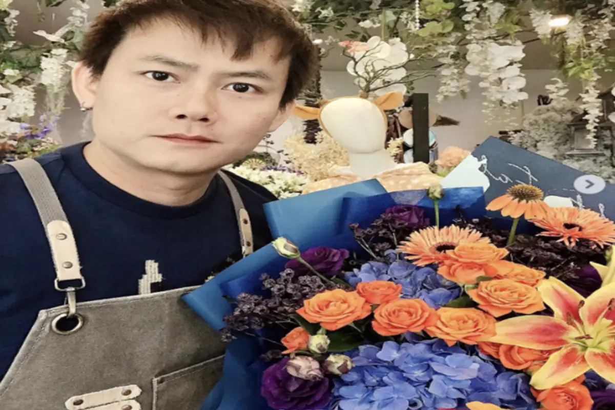 A man is holding a bouquet of flowers he created at Flowers First flower shop in Chiang Mai