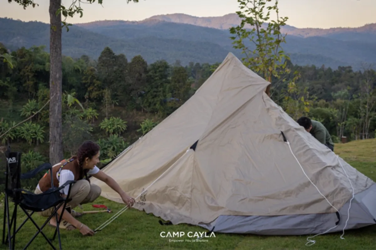A man and a woman are setting up a tent at Camp Cayla - Eden in Chiang Mai